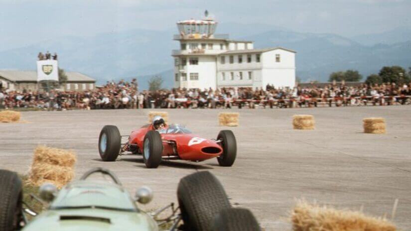 Lorenzo Bandini, ganador de la carrera, pasa junto a un coche roto.